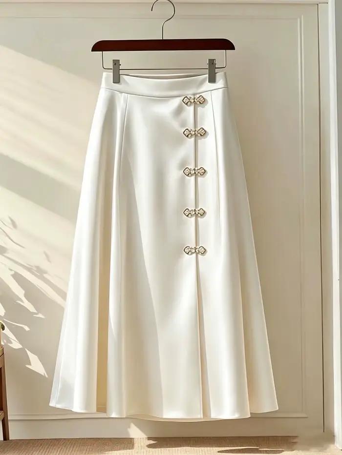 Jupe mi-longue évasée en satin brillant ivoire, taille haute, avec boutons grenouillère chinois en s