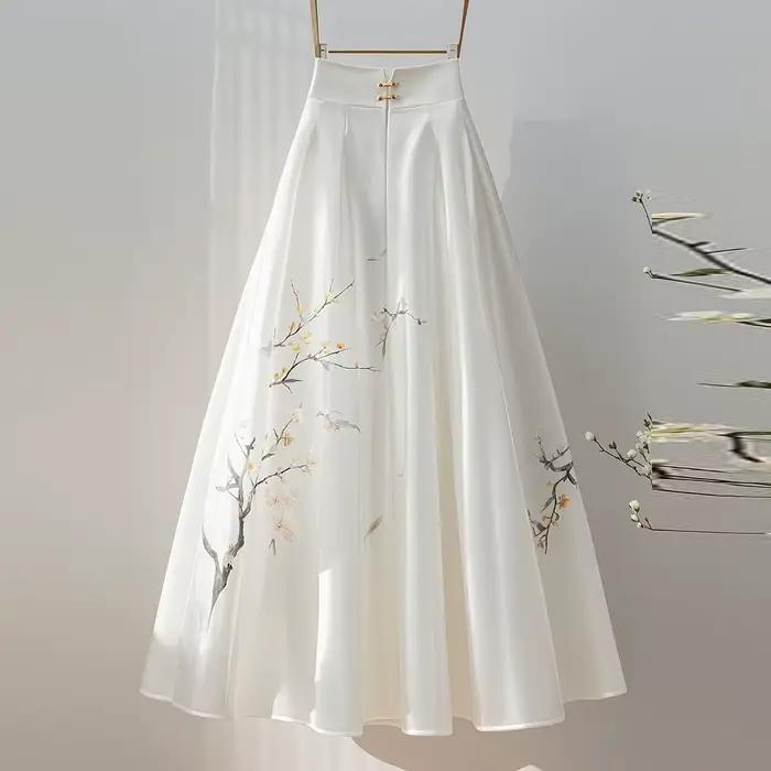 Jupe midi blanche avec un sentiment de drapé pour les femmes d'automne 2025, nouveau style super fée