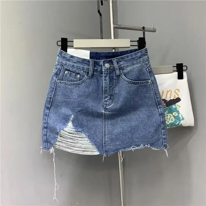 Jupes demi-corps en Denim irrégulier lavé et portées. Nouvelle mode d'été et jupe courte