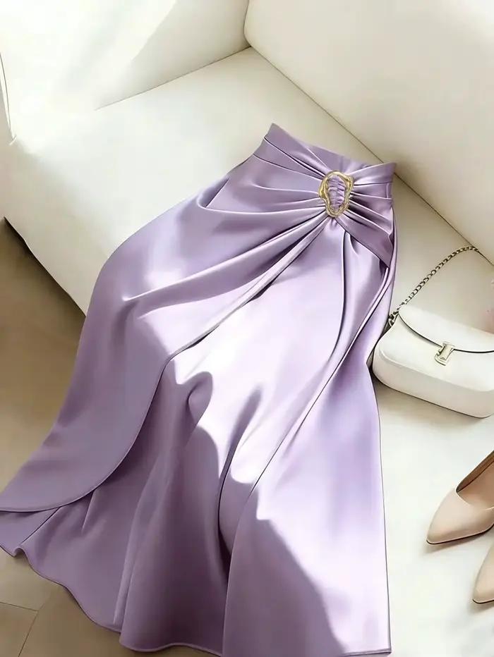 Jupe midi en satin brillant lilas, taille haute, froncée devant, avec boucle ovale dorée, fente haute, coupe évasée en A, élégante