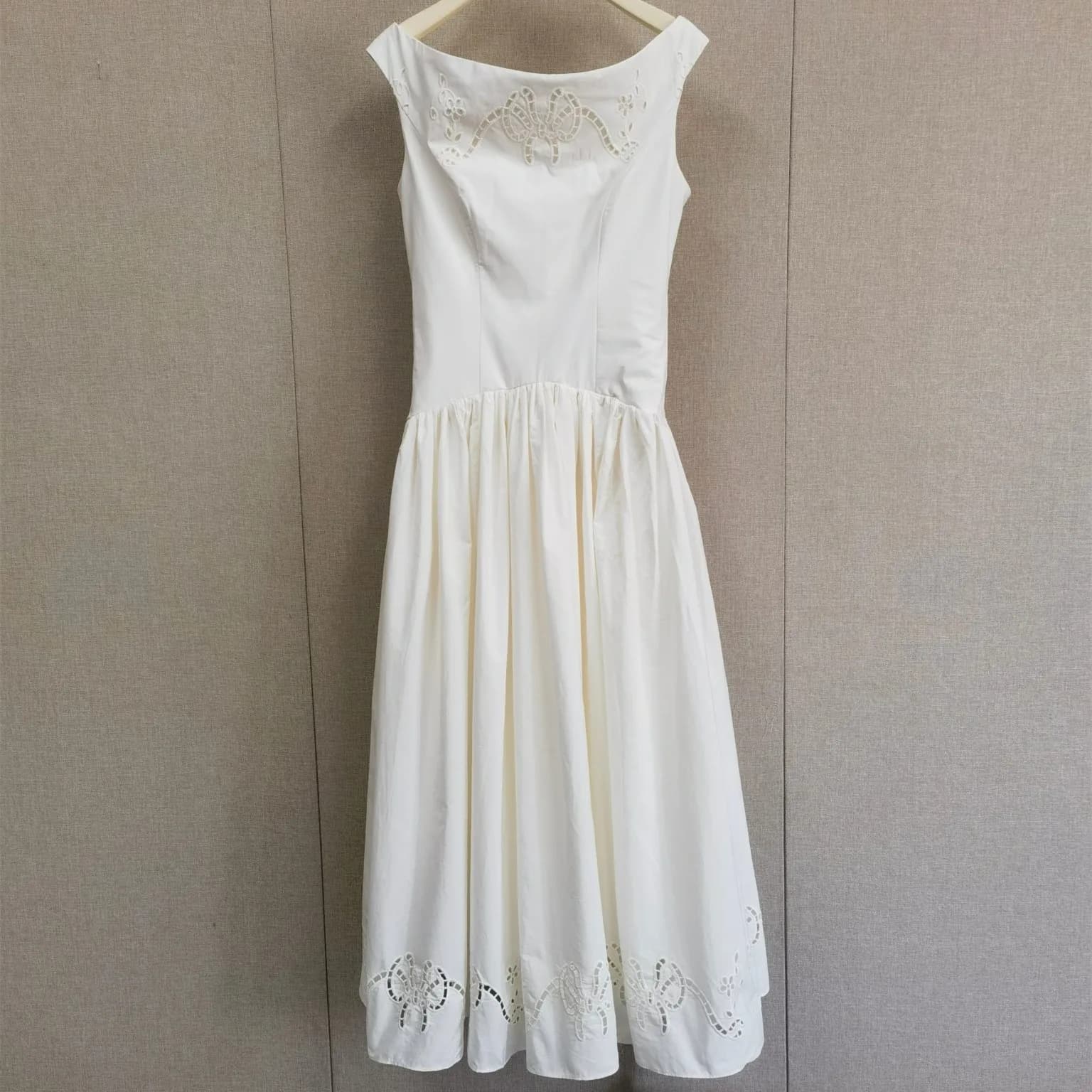 Robe mi-longue élégante pour femme, sans manches, col bateau, avec broderie de nœuds ajourée et tail
