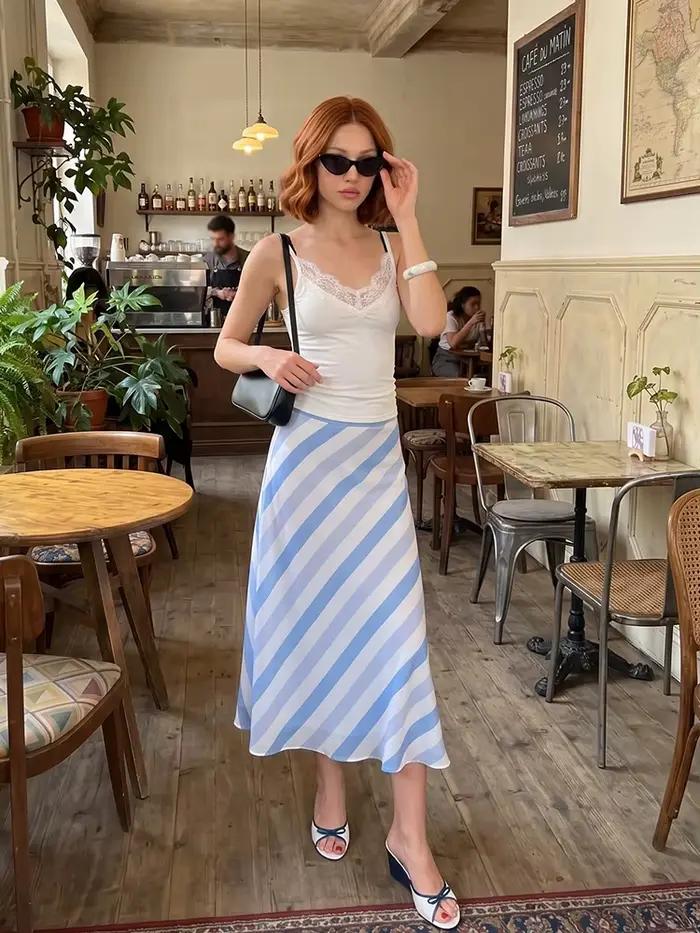 Jupe midi élégante et minimaliste en satin rayé bleu et blanc, taille haute diagonale, fluide et soyeuse, idéale pour l'été, le bureau ou les tenues décontractées.