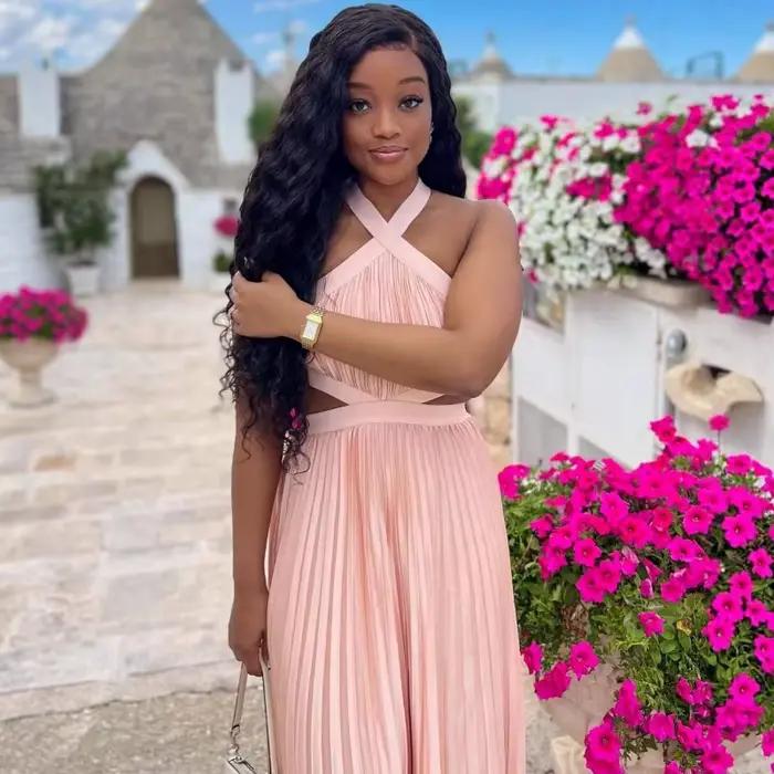 Robe longue plissée rose poudré en satin pour femme, style africain élégant, avec découpes à la taille, sans manches, pour soirée ou événement.