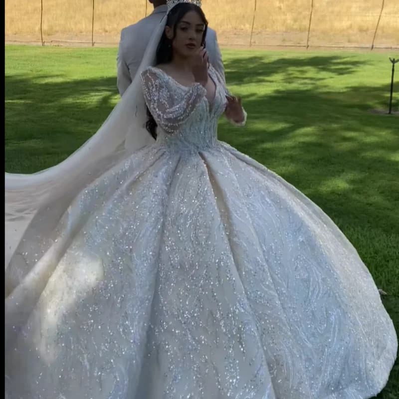 Robe de mariée luxueuse et sexy sur mesure avec une jupe volumineuse, un décolleté profond en V, des