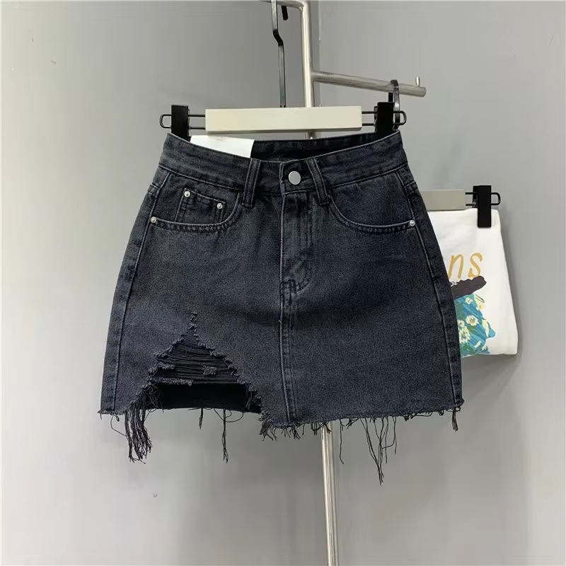 Jupes demi-corps en Denim irrégulier lavé et portées. Nouvelle mode d'été et jupe courte en Denim ta